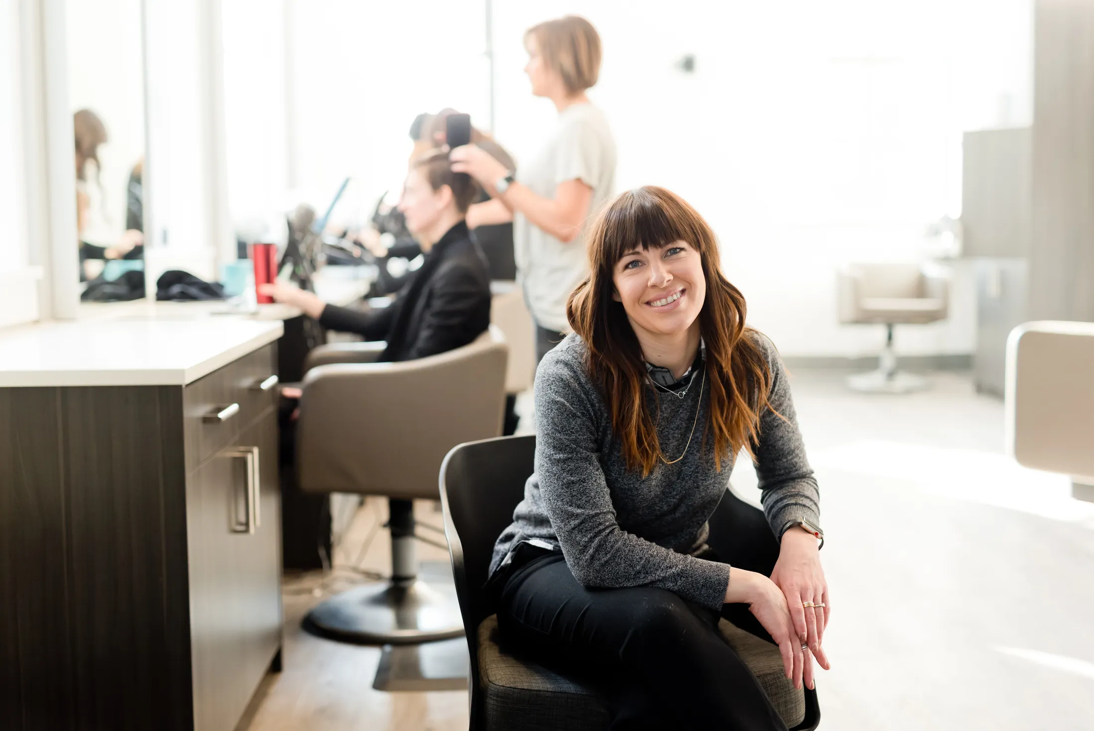 Salon owner sitting on a chair in her salon.